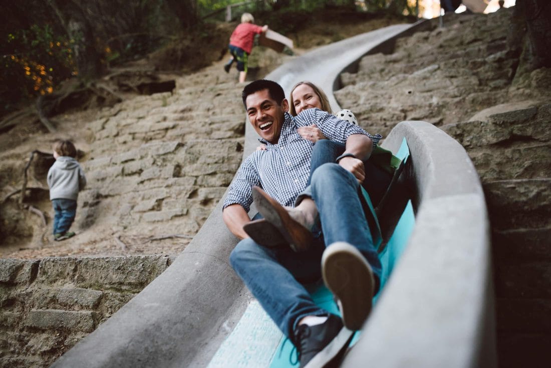 Engagement couple on slide in codornices park in berkeley