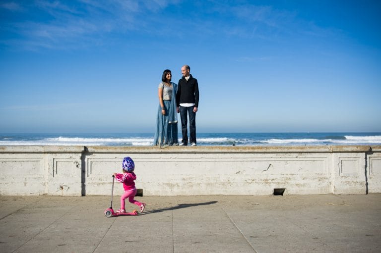 Kids ridding in front of couple at san francisco engagement