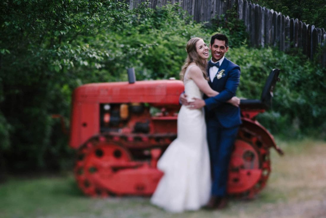 couple laughing on tractor at radonich ranch wedding