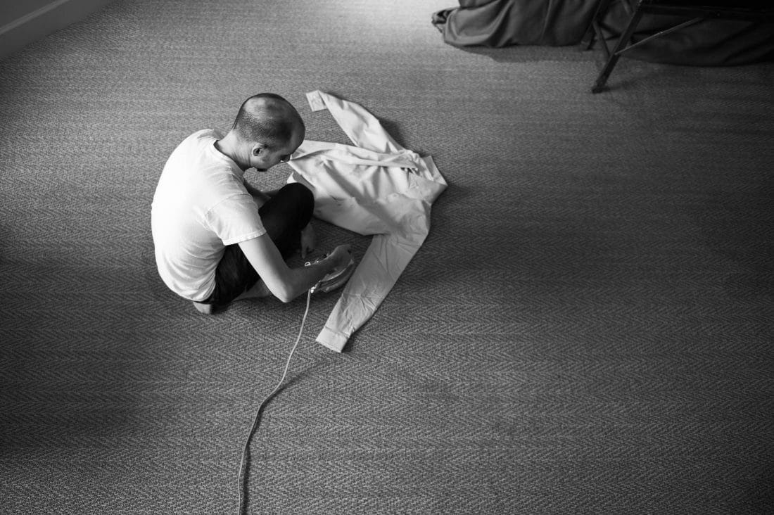 groom ironing shirt before wedding at Ramekins Culinary School