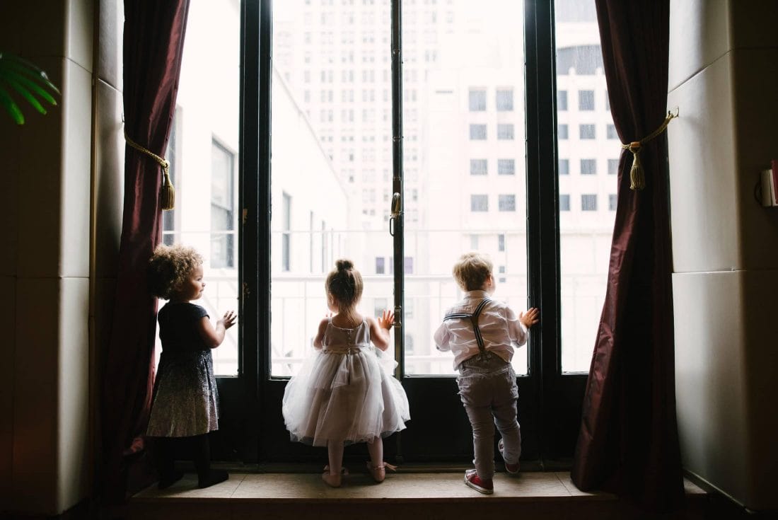 Kids looking out window at wedding at SF City Club