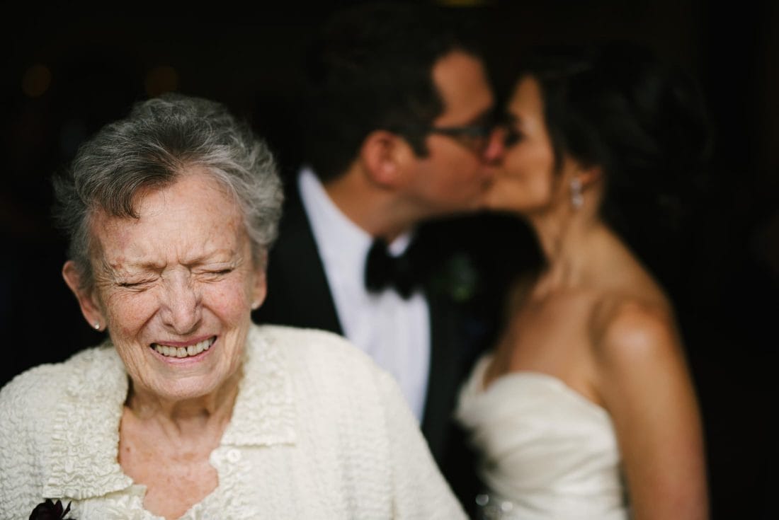 Grandma laughing while couple kiss at SF City Club