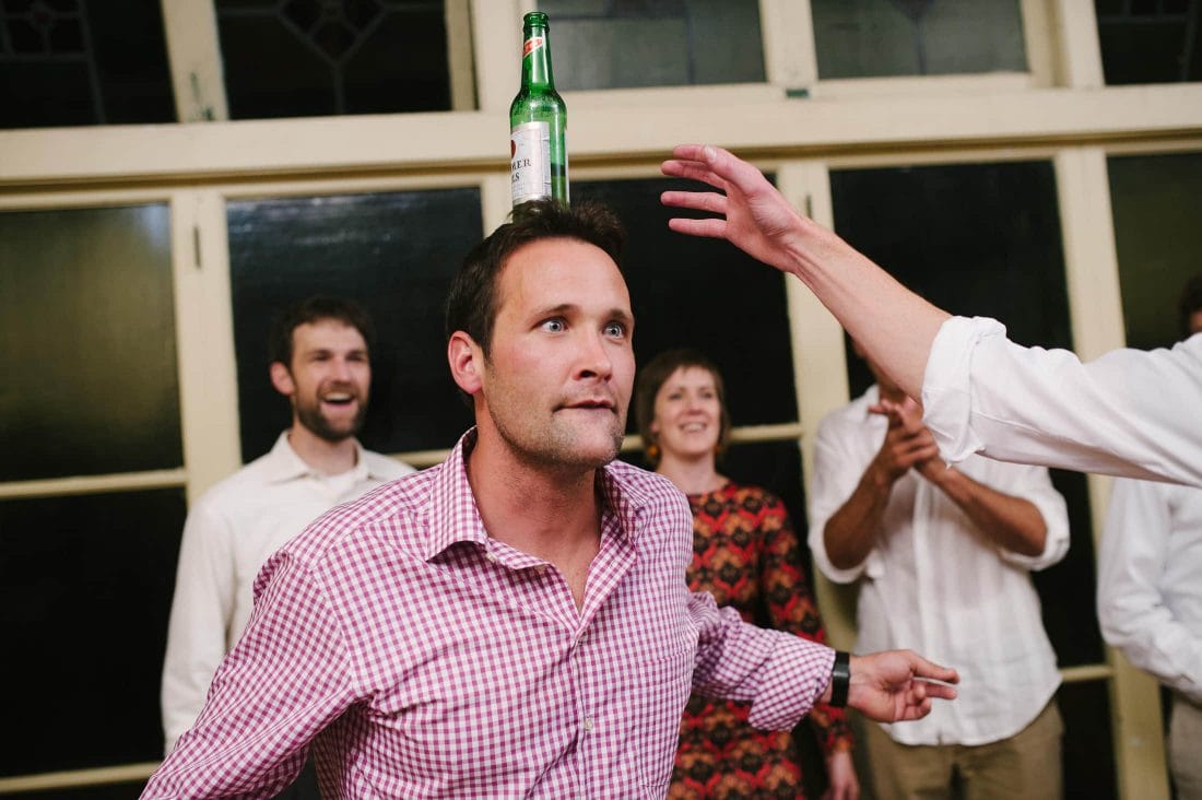 fun dance floor shot of guest balancing beer on head at berkeley wedding